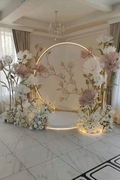 a white room with flowers and lights on the floor, in front of a circular mirror