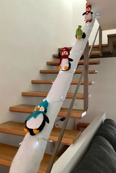 the penguins are lined up on the stair railing to go down the flight of stairs