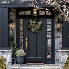 a black front door with two potted plants