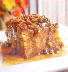 a close up of a piece of cake on a plate with syrup and pecans