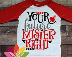 a red and white shirt with the words your future master right on it next to a flower