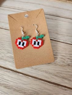 the earrings are made out of beads and have an apple on them