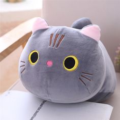 a gray cat pillow sitting on top of a table