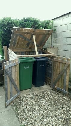 an outdoor storage area with trash cans and bins