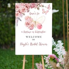 a welcome sign with pink flowers and butterflies