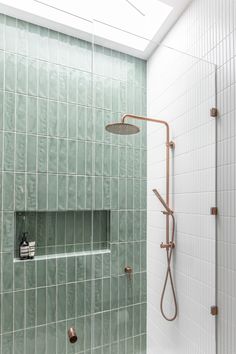 the shower head is mounted on the wall next to the tiled bathtub in this bathroom