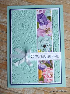 congratulations card with flowers and ribbon on the front, in pastel blue tones that say congratulations