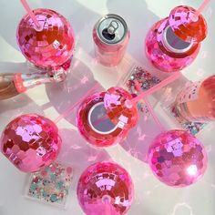 several pink objects are arranged on a table with confetti in the middle and one is empty