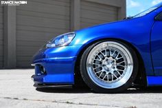 a blue car parked in front of a garage