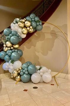 balloons are arranged in the shape of a spiral staircase with gold and white balls on it