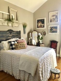 a bed with white bedspread sitting in a bedroom next to pictures on the wall