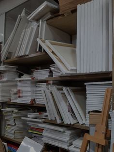 many books are stacked up on shelves in a room with ladders and other items