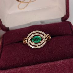 This beautiful east west ring features a vibrant green emerald in 14k yellow gold with a pave diamond double halo in a unique design. Green Emerald Diamond Ring With Pave Setting, 14k Gold Green Emerald Ring With Halo, Green Emerald Ring With Pave Setting, Green Emerald Ring With Pave Setting For May Birthstone, May Birthstone Emerald Ring With Pave Setting, Green Emerald Ring With Halo Style Fine Jewelry, 14k Gold Green Halo Ring, 14k Gold Green Cluster Ring With Halo Setting, Green Emerald Diamond Ring With Halo