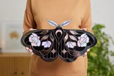 a woman holding a stained glass butterfly in her hands