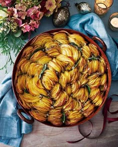 a bowl filled with bananas sitting on top of a table next to flowers and candles