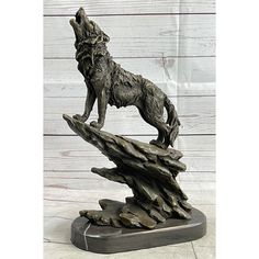 a statue of a wolf standing on top of a rock