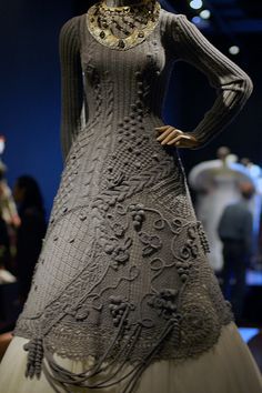 a woman's dress is on display at a fashion show with people in the background