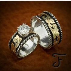 two wedding rings sitting next to each other on top of a brown cloth covered surface