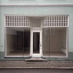 an empty store front with two doors and no one in the room on the sidewalk