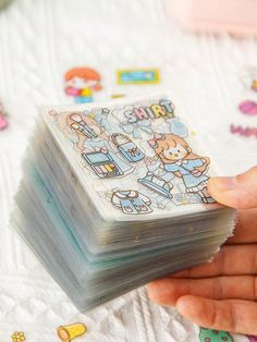 a person holding a stack of stickers in their hand