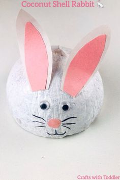 a paper mache bunny sitting on top of a white surface with the words coconut shell rabbit