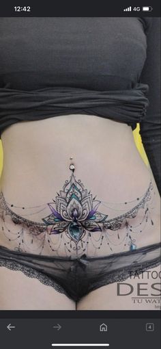 a woman's stomach with an intricate tattoo on the side, and her belly