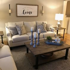 a living room with two couches, a coffee table and candles on the end tables