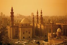 an aerial view of a city with tall buildings and minarets in the foreground