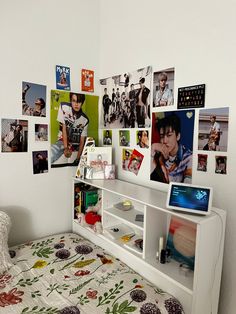 there is a bed with many pictures on the wall above it and a white headboard