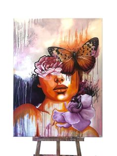 a painting on an easel with a butterfly and flowers