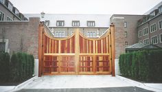 a large wooden gate in front of a brick building