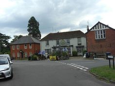 a white car parked in front of a building with two storyed houses on both sides