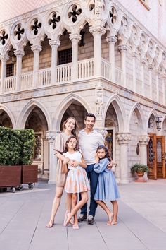 a family poses for a photo in front of an ornate building