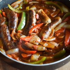 a pan filled with meat and vegetables on top of a wooden table