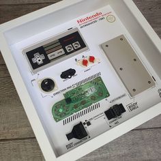 an old nintendo game system is displayed in a shadow box