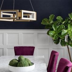 a dining room table with purple chairs and a white bowl filled with broccoli