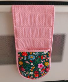 a pink oven mitt hanging on the wall