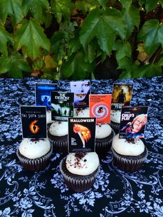 there are cupcakes that have been placed on the table with movie posters in them