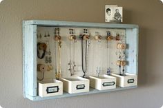 a wall mounted jewelry organizer with five drawers