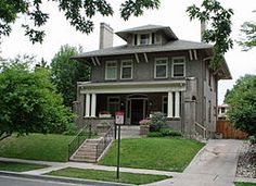 a large house with a lot of windows and lots of green grass on the front lawn