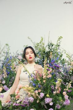 a woman is sitting in the middle of flowers