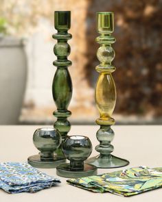 three glass candlesticks sitting on top of a table