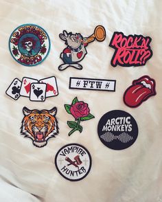 various patches and stickers on a white sheet that says rock'n roll?