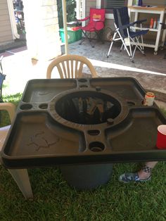 a child's table and chair in the grass with an upside down cup on it