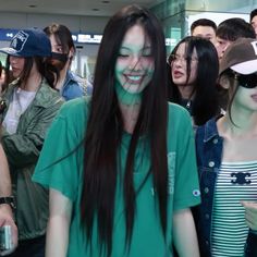 a group of people standing around each other with green paint on their face and eyes