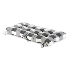 a black and white checkered dog bed with zippers on the bottom, in front of a white background