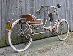 an old bicycle parked next to a wooden fence