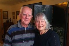 an older man and woman standing next to each other