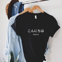 Elevate your streetwear with our 'こんにちは' (Konnichiwa / Hello) T-shirt, featuring minimalist Japanese design. Perfect for men and women, this Hiragana tee is a must-have souvenir from Tokyo. Whether you're moving to Japan or just a Japan enthusiast or Japanese language lover, this Japanese quote tee adds authentic flair to your wardrobe. Embrace Japanese culture with this stylish shirt, ideal for travelers and Japanese teachers alike. Shop now and carry a piece of Japan with you wherever you go! Harajuku Style Crew Neck Shirt With Screen Print, Harajuku Style T-shirt With Screen Print And Relaxed Fit, Harajuku Style Relaxed Fit Screen Print T-shirt, Japan Symbol, Japanese Quote, Design Japonais, Minimalist Japanese, Japanese Shirt, Japanese Quotes