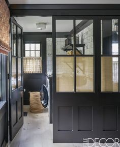 an open door leading to a washer and dryer in a room with brick walls